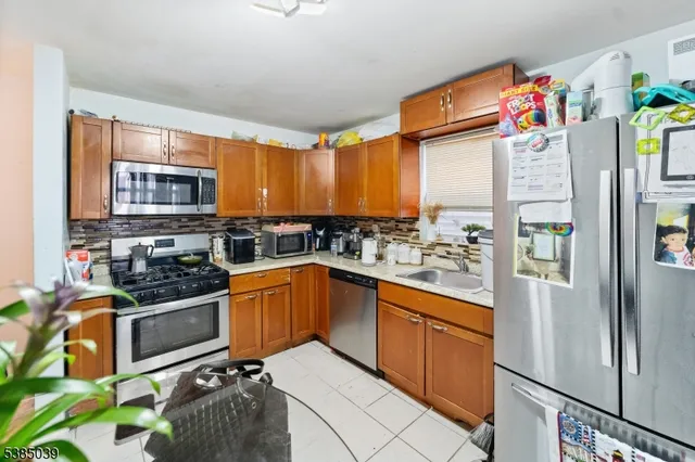 a kitchen with stainless steel appliances granite countertop a refrigerator and a stove top oven