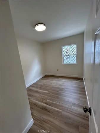 a view of kitchen with refrigerator and wooden floor