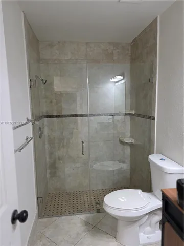 a bathroom with a granite countertop toilet and a sink