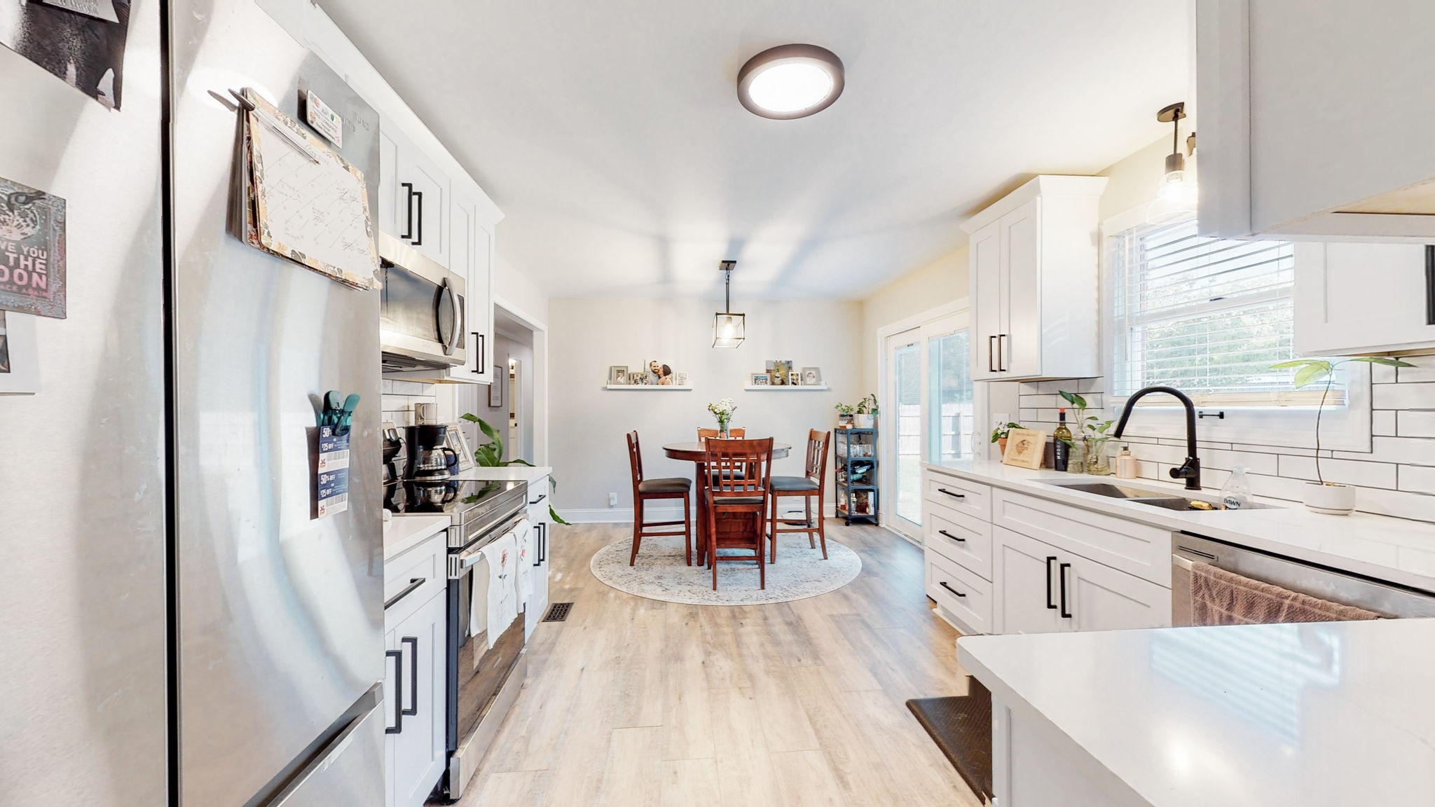 506 Thatcher Trace Murfreesboro, TN 37129 - Photo 9 of 22 a large kitchen with stainless steel appliances a stove a sink a chimney and a dining table next to a window