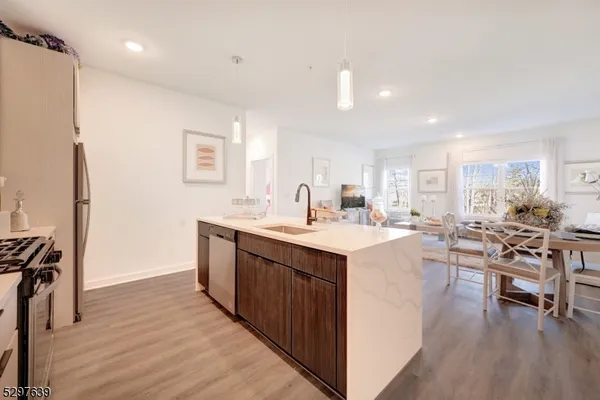 a kitchen with a sink a counter top space stainless steel appliances and a window