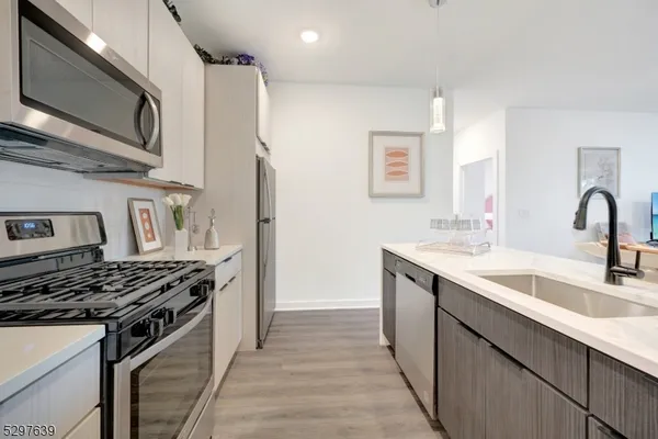 a kitchen with stainless steel appliances a sink stove and cabinets