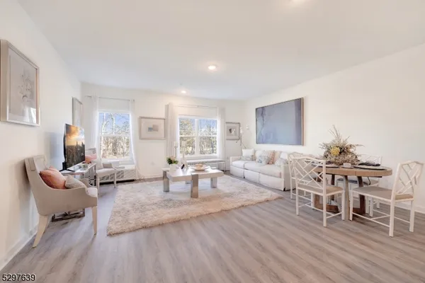 a living room with furniture a wooden floor and next to a window