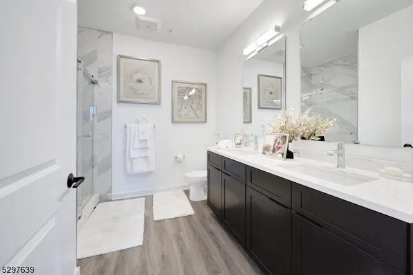 a spacious bathroom with a double vanity sink a mirror and a shower