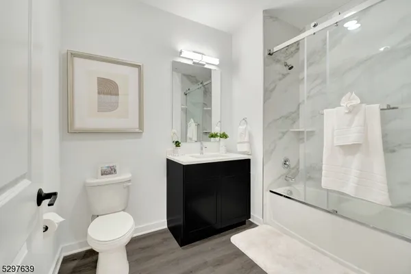 a bathroom with a sink toilet a mirror and shower