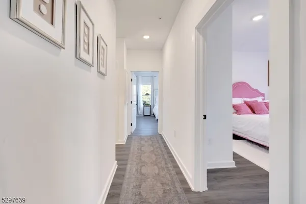 a view of a hallway with wooden floor and closet