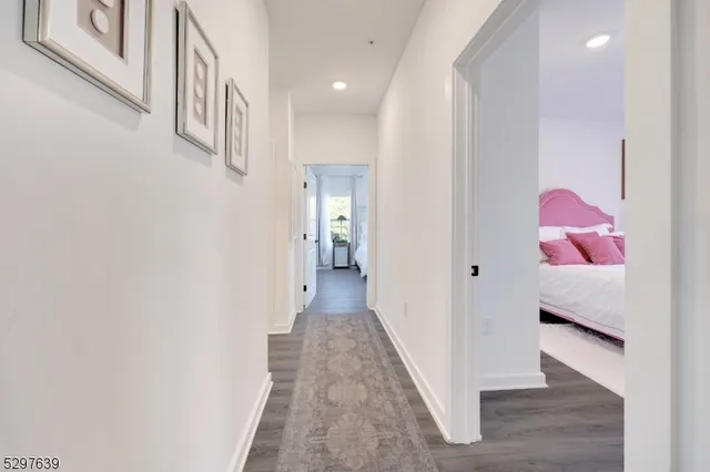 a view of a hallway with wooden floor and closet