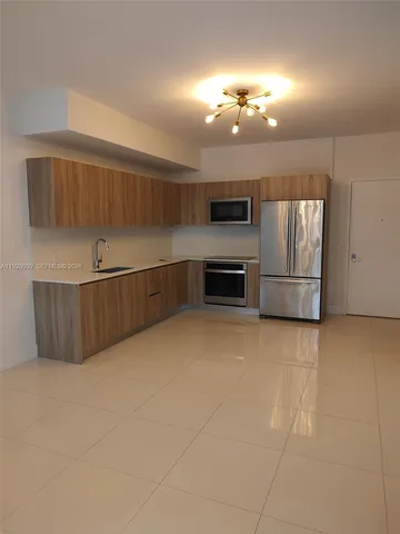 a view of a kitchen with a sink and dishwasher a refrigerator oven