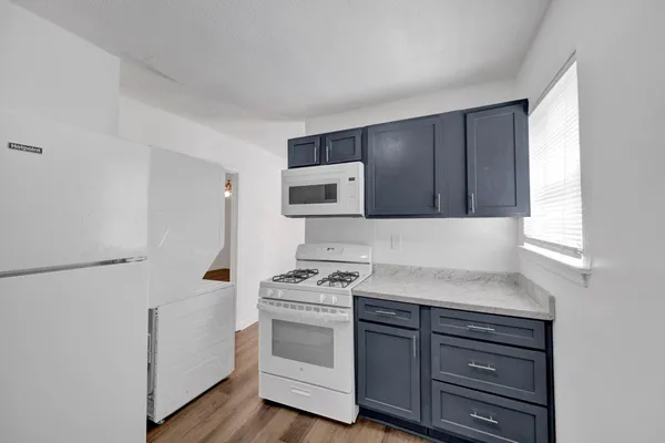 a kitchen with granite countertop cabinets appliances and a window