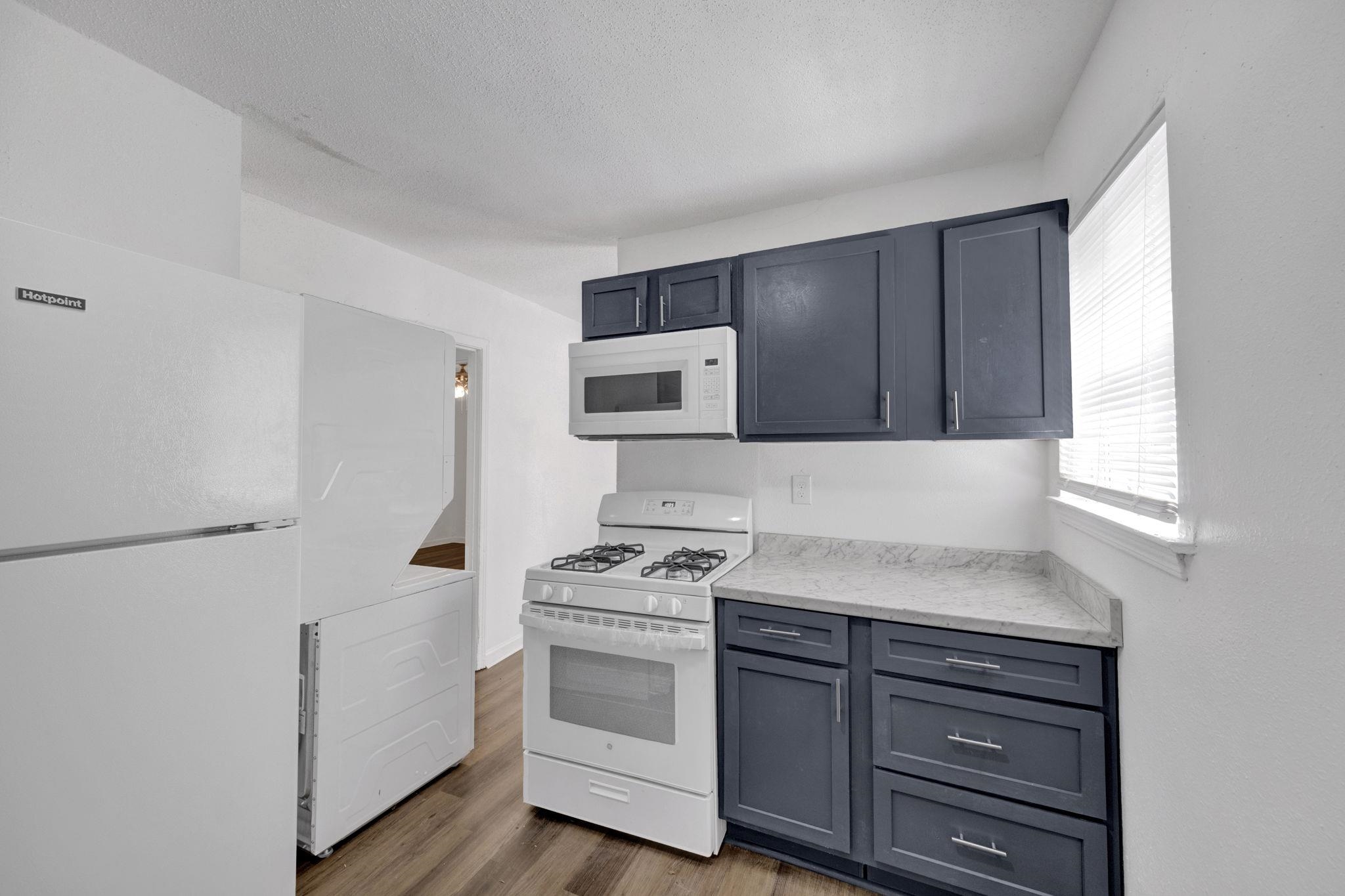 2966 Yale Avenue, Unit 3 Memphis, TN 38112 - Photo 4 of 24 Kitchen featuring white appliances, wood finished floors, light stone countertops, and gray cabinetry