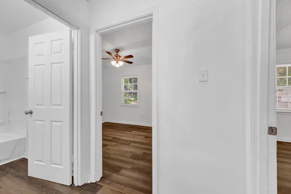 a view of a hallway with wooden floor and closet