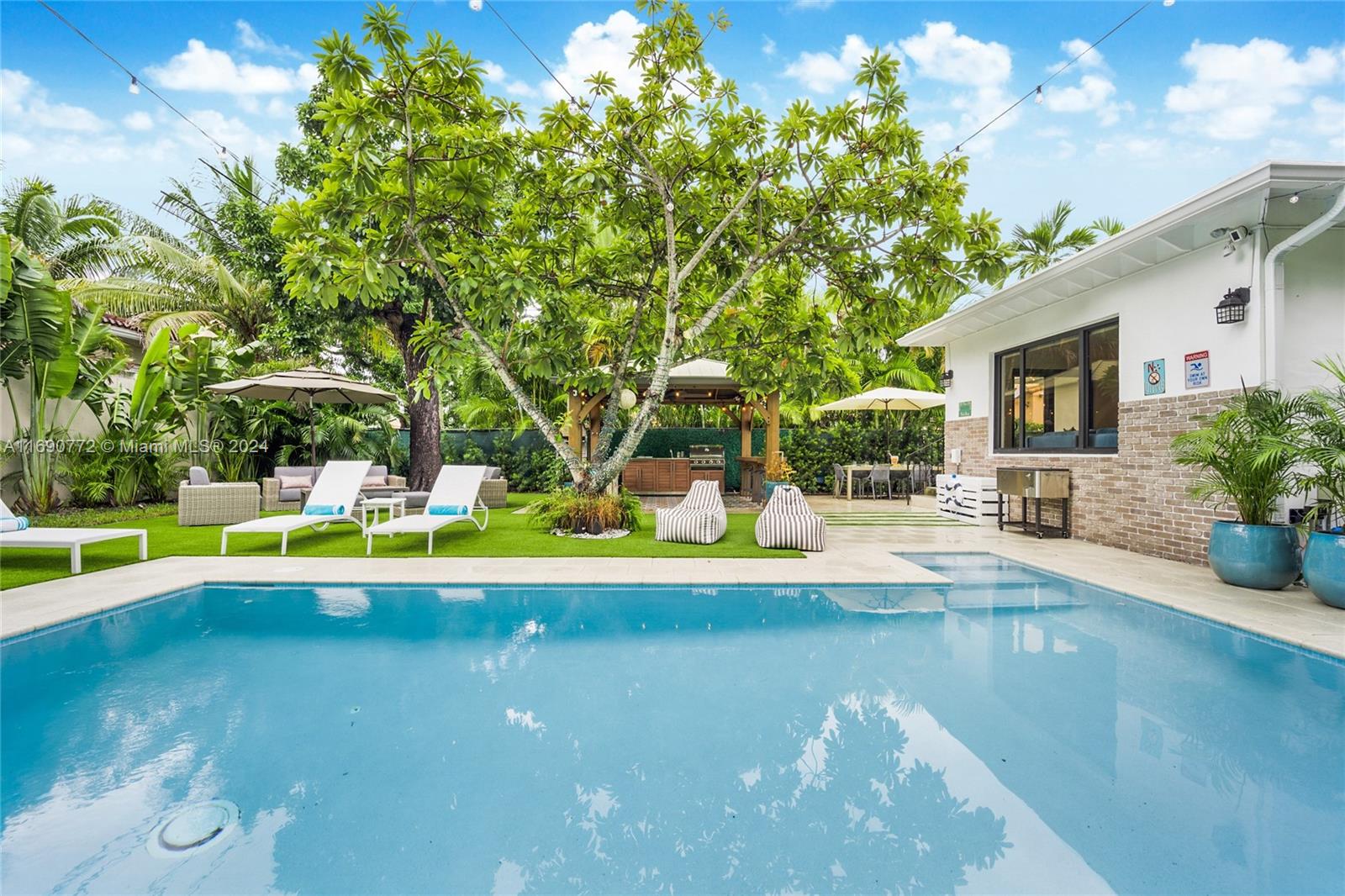 320 Southwest 24th Road Miami, FL 33129 - Photo 2 of 27 a view of swimming pool with sitting area and large trees