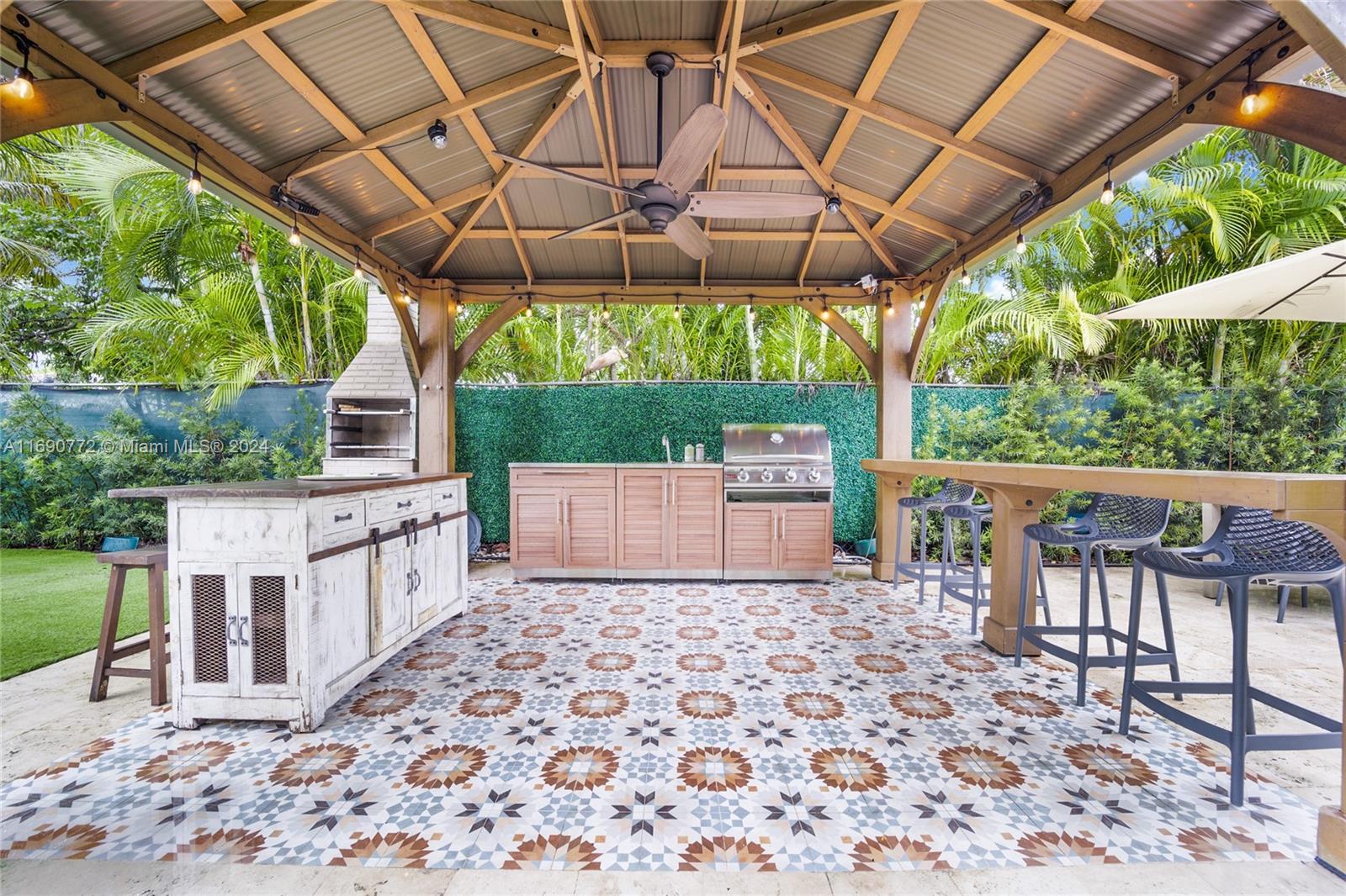 320 Southwest 24th Road Miami, FL 33129 - Photo 4 of 27 a view of a patio with a table and chairs under an umbrella with a small yard