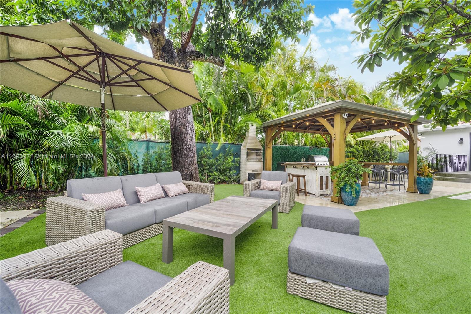 320 Southwest 24th Road Miami, FL 33129 - Photo 6 of 27 a view of a patio with couches and a table and chairs under an umbrella