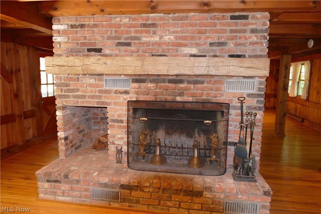 17340 Huntley Road Huntsburg, OH 44046 - Photo 13 of 24 Details featuring beamed ceiling, a fireplace, light hardwood / wood-style floors, and wooden walls