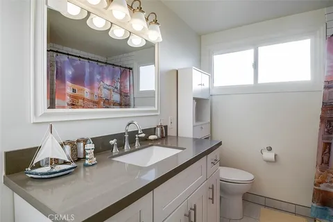 a bathroom with a granite countertop sink a toilet and a mirror