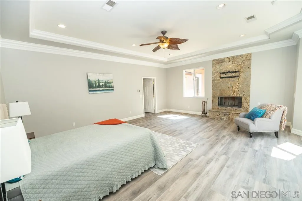 12841 Stone Canyon Road Poway, CA 92064 - Photo 12 of 25 a bedroom with a bed and wooden floor