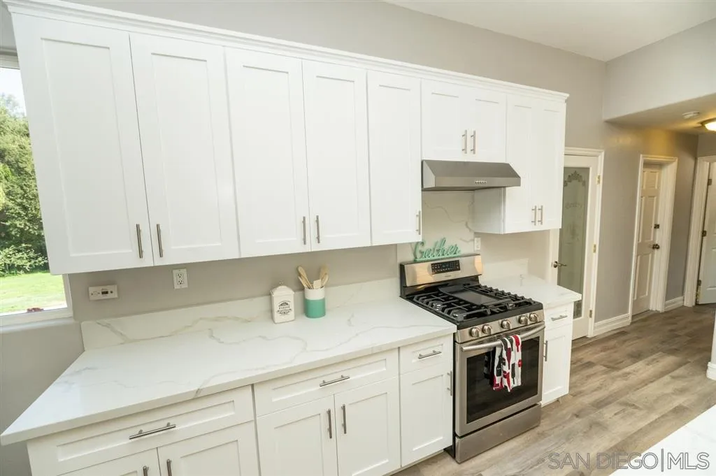 12841 Stone Canyon Road Poway, CA 92064 - Photo 8 of 25 a kitchen with granite countertop a sink a stove and cabinets