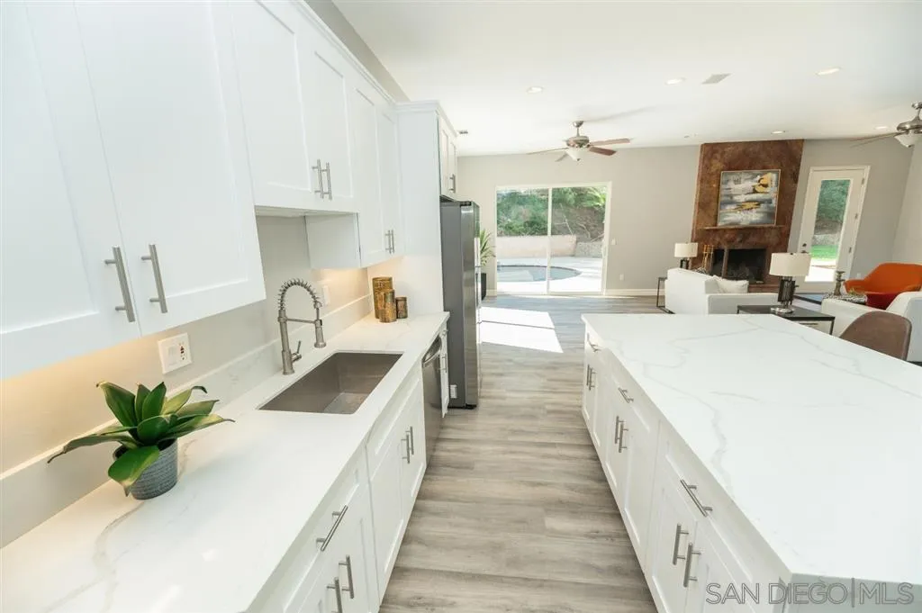 12841 Stone Canyon Road Poway, CA 92064 - Photo 9 of 25 a large white kitchen with sink and a large window