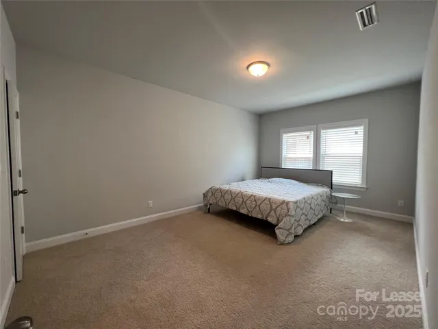 a bed sitting in a bedroom next to a window