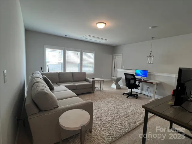 a living room with furniture a rug and a flat screen tv