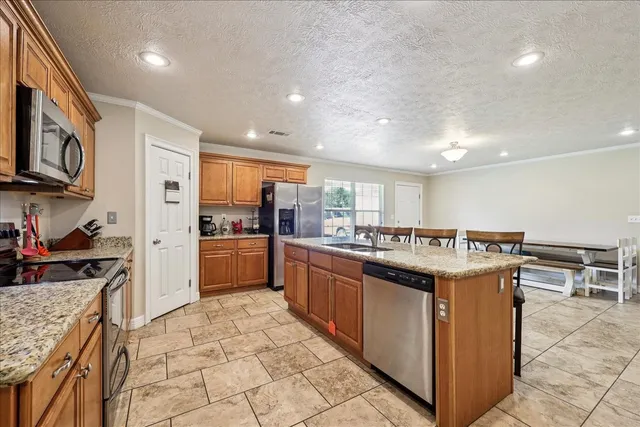 a kitchen with stainless steel appliances granite countertop a stove top oven a sink a counter top space and cabinets