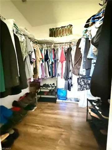 a view of walk in closet with clothes and shoes