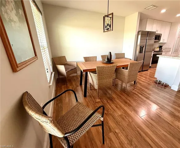 a view of a dining room with furniture a rug and wooden floor