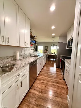 a large kitchen with stainless steel appliances granite countertop a lot of counter space and a sink
