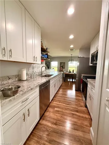 a large kitchen with stainless steel appliances granite countertop a lot of counter space and a sink