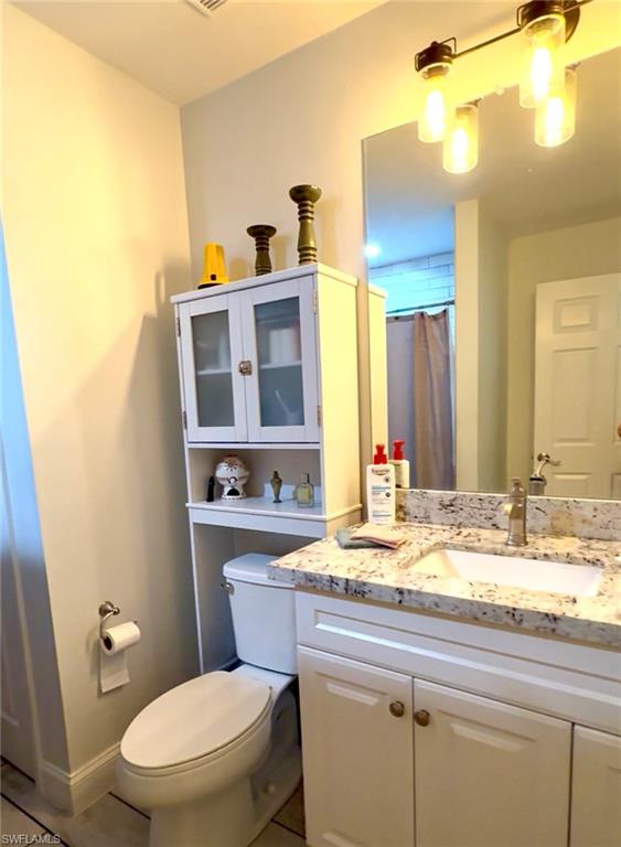 1180 Calico Street LaBelle, FL 33935 - Photo 9 of 19 a bathroom with a granite countertop toilet sink and mirror