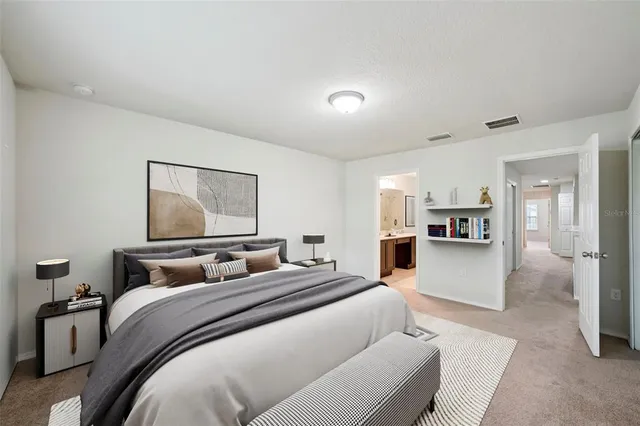 a bedroom with a large bed and a view of kitchen