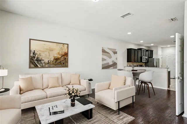 a living room with furniture kitchen view and a window