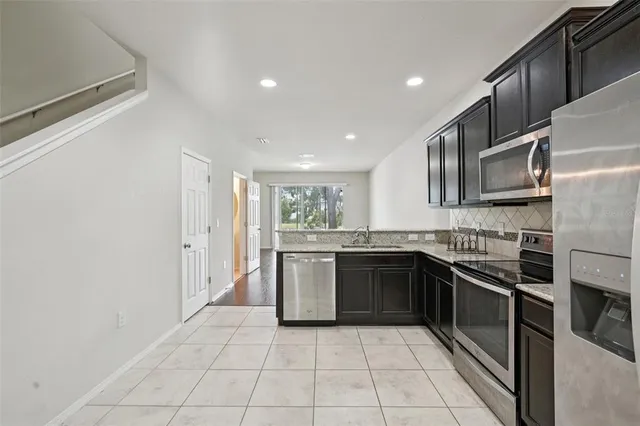 a large kitchen with stainless steel appliances granite countertop a stove and a sink