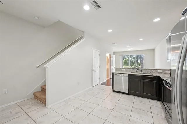 a kitchen with stainless steel appliances granite countertop a refrigerator and a sink