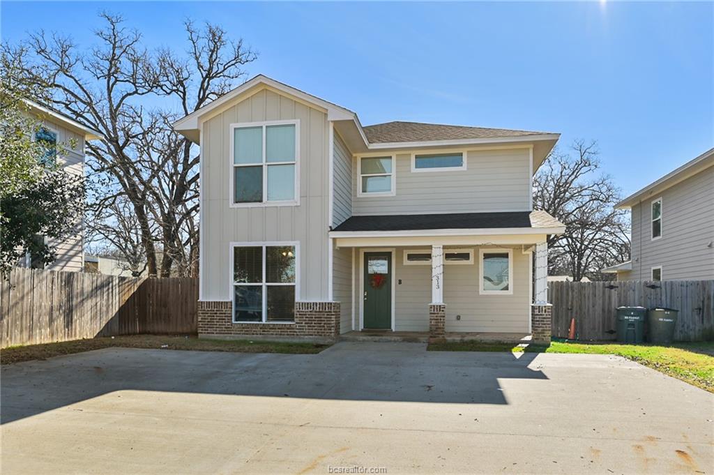 View of front of house with brick siding, fence, b