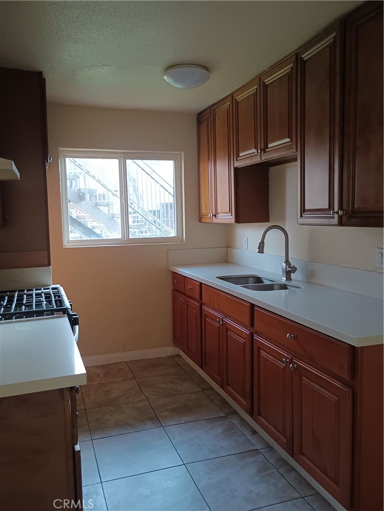 648 Abbey Lane Pomona, CA 91767 - Photo 3 of 6 a kitchen with stainless steel appliances granite countertop a sink stove and cabinets