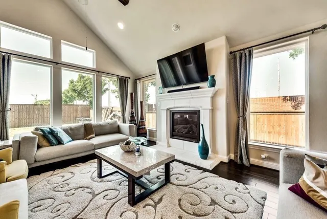 a living room with furniture fireplace and a large window