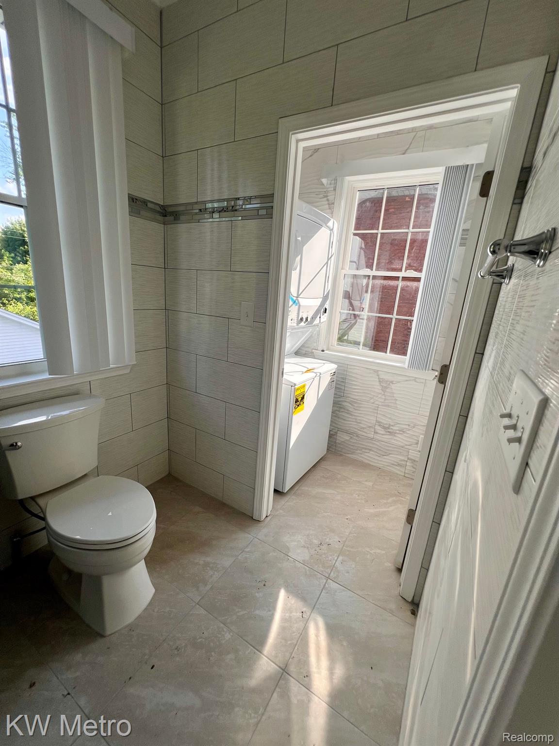 939 Webb Street Detroit, MI 48202 - Photo 11 of 19 Bathroom featuring light-toned rectangular wall tiling with a decorative mosaic accent band