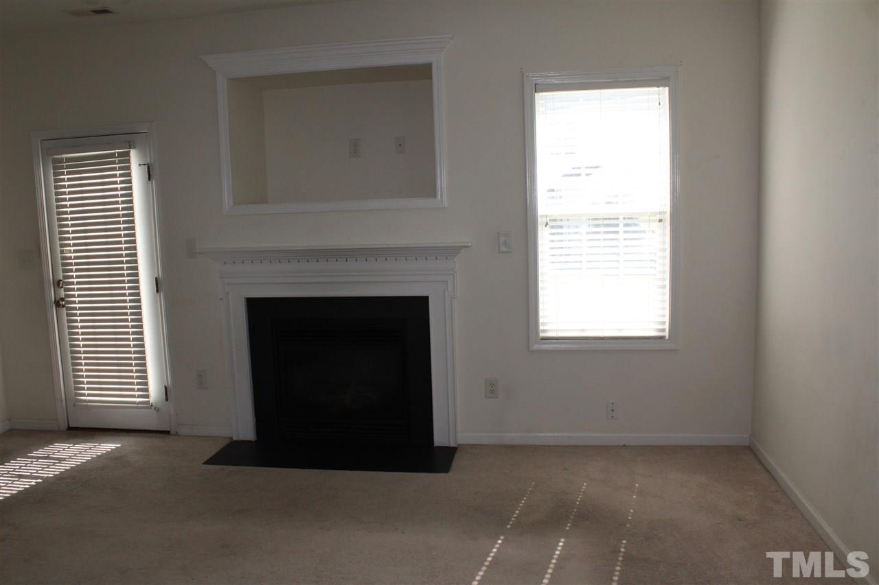 8518 Boysenberry Lane Raleigh, NC 27616 - Photo 14 of 17 a living room with a fireplace and a window