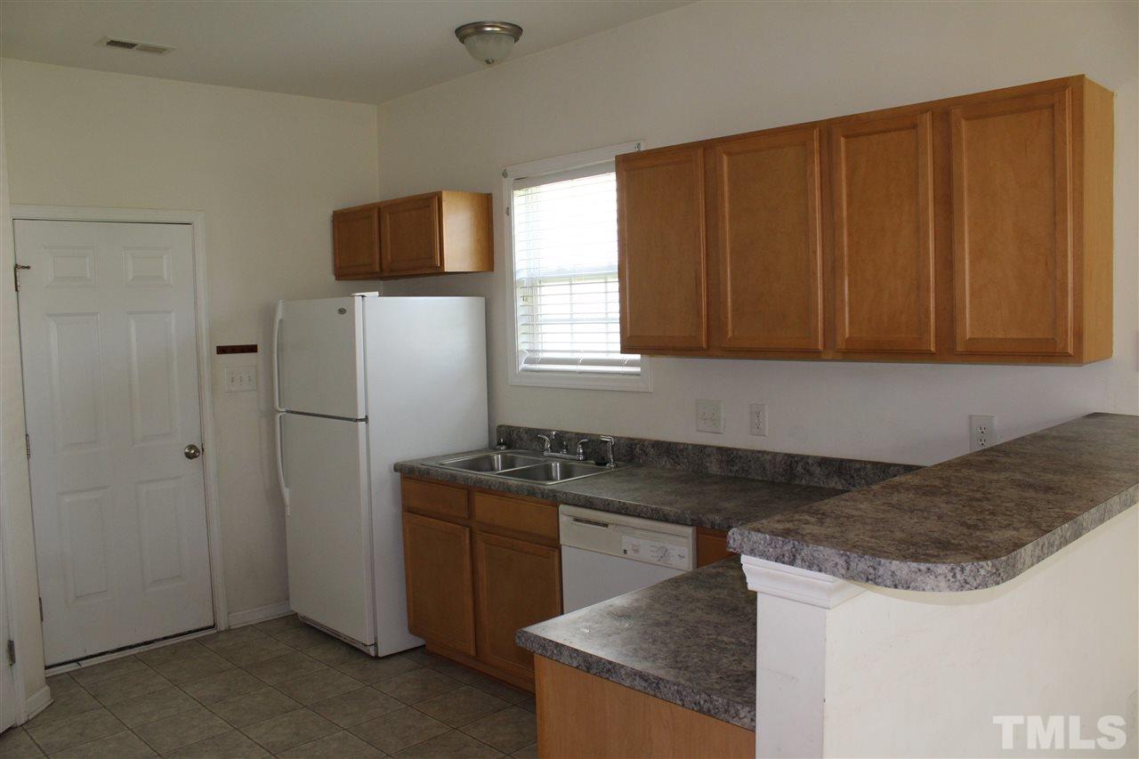 8518 Boysenberry Lane Raleigh, NC 27616 - Photo 16 of 17 a kitchen with granite countertop a sink a stove and a microwave