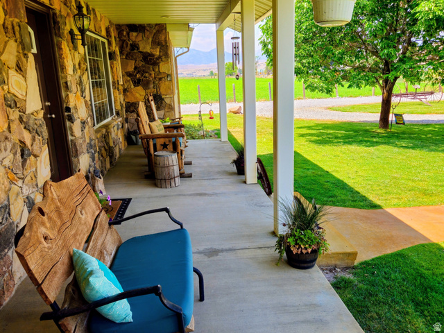 802 East 3200 Road North Preston, ID 83263 - Photo 23 of 59 Expansive covered porch featuring a stone-clad exterior, concrete flooring, and white support columns