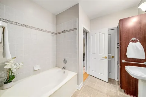 a bathroom with a tub shower and sink