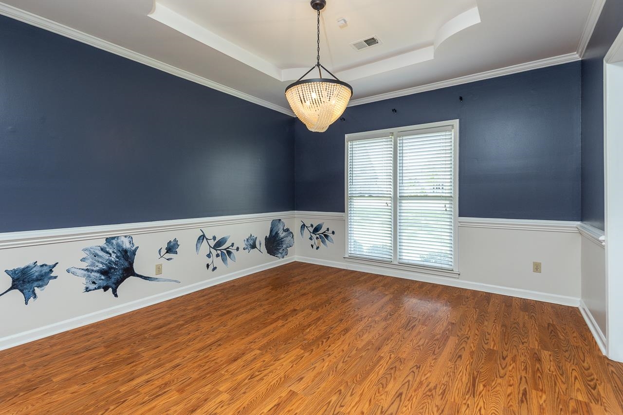 3358 Bailey Station Road Collierville, TN 38017 - Photo 8 of 31 Empty room with wood-type flooring, a tray ceiling, crown molding, and a chandelier