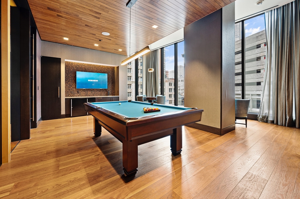 1 Franklin Street, Unit 1002 Boston, MA 02110 - Photo 16 of 21 a living room with pool table and a flat screen tv