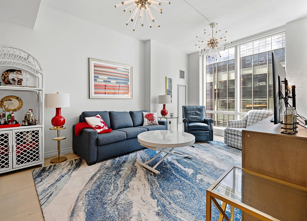 1 Franklin Street, Unit 1002 Boston, MA 02110 - Photo 2 of 21 a living room with furniture and a large window