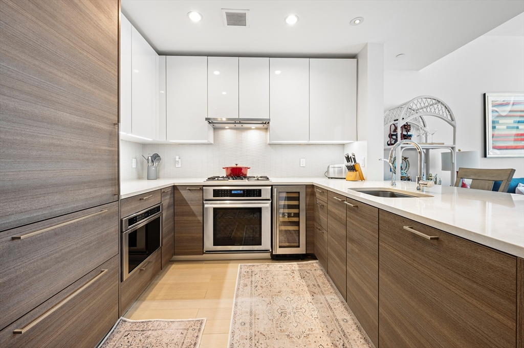 1 Franklin Street, Unit 1002 Boston, MA 02110 - Photo 5 of 21 a kitchen with stainless steel appliances a stove sink and cabinets