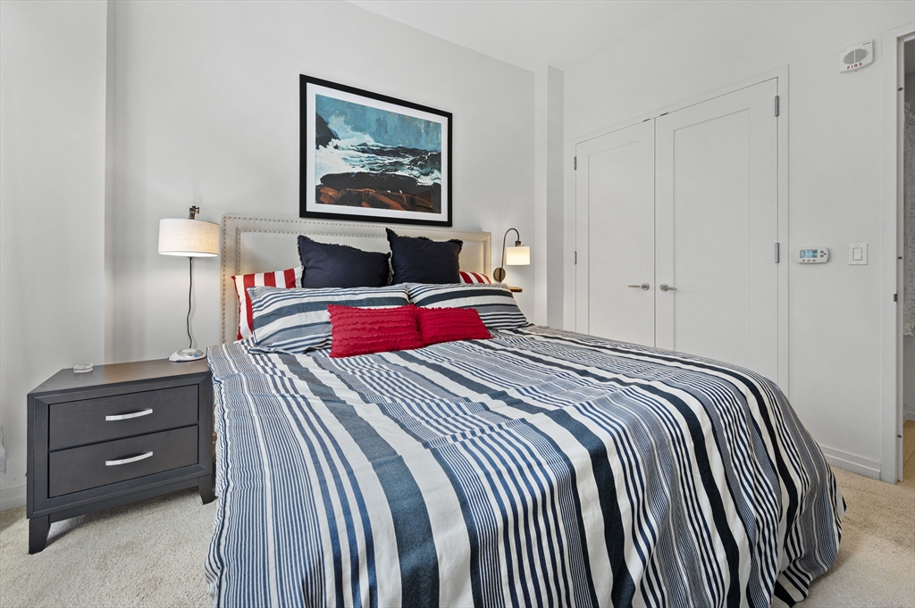 1 Franklin Street, Unit 1002 Boston, MA 02110 - Photo 7 of 21 a bedroom with a bed and a dresser
