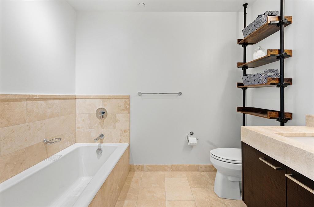 1 Franklin Street, Unit 1002 Boston, MA 02110 - Photo 9 of 21 a bathroom with a sink a toilet and shower