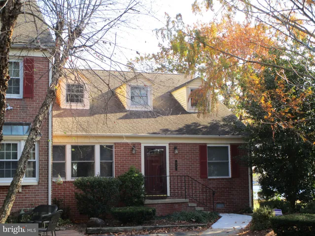a view of a brick house with a large windows and a large tree